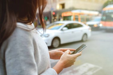 Güzel ve genç birbayan Bulvarı kentsel sahne, şehir merkezinde, günbatımında smartphone holding