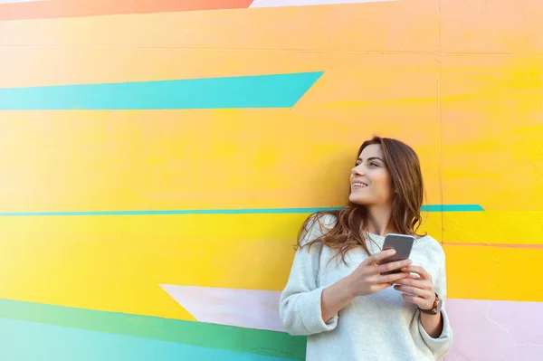 Utomhus Porträtt Hipster Kvinna Med Smart Telefon Mot Färgglada Gatan — Stockfoto