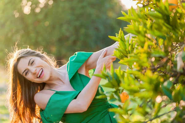 オレンジ果樹園の夕日のうれしそうな若い女性は屋外笑顔 健康的なライフ スタイルのコンセプトは 肌や髪のケアの概念 — ストック写真