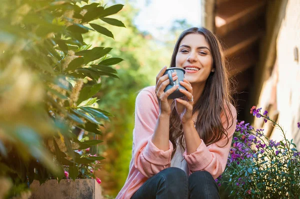 Mujer Joven Relajada Sonriendo Mirando Cámara Sentada Terraza Casa Sosteniendo —  Fotos de Stock