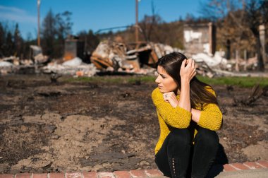 Üzgün kadın ev sahibi el ile başını tutan kontrol ev ve avlu ateş felaketinden sonra yangın felaket kaza sonuçlarını yanmış. Yangın felaketi, kaybı ve umutsuzluk kavramı sonra Harabeleri.