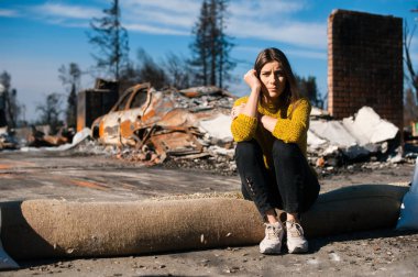 Üzgün kadın ev sahibi el ile başını tutan kontrol ev ve avlu ateş felaketinden sonra yangın felaket kaza sonuçlarını yanmış. Yangın felaketi, kaybı ve umutsuzluk kavramı sonra Harabeleri.
