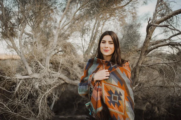 Beautiful hipster traveler girl in gypsy look in desert nature, looking at camera and smiling.  Artistic photo of young hipster traveler girl in gypsy look, in Coachella Valley in a desert valley in Southern California.