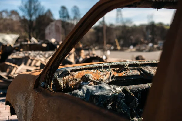 Exterior close-up of a burned to the ground car wreck.