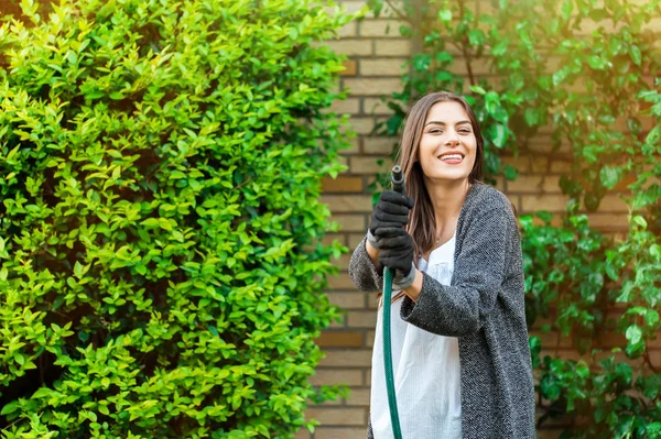 Mujer Joven Sonriente Con Manguera Jardín Regando Patio Trasero Con —  Fotos de Stock