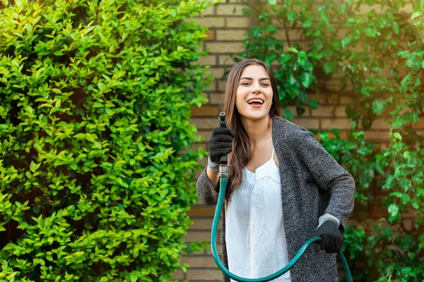 Mujer Joven Sonriente Con Manguera Jardín Regando Patio Trasero Con —  Fotos de Stock