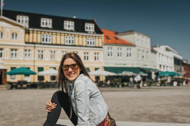 Genç güzel kadın turist şehir merkezinde oturan ve güneşli bir gün zevk.