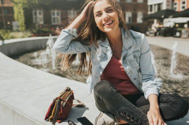 Genç güzel kadın turist şehir merkezinde oturan ve güneşli bir gün zevk.