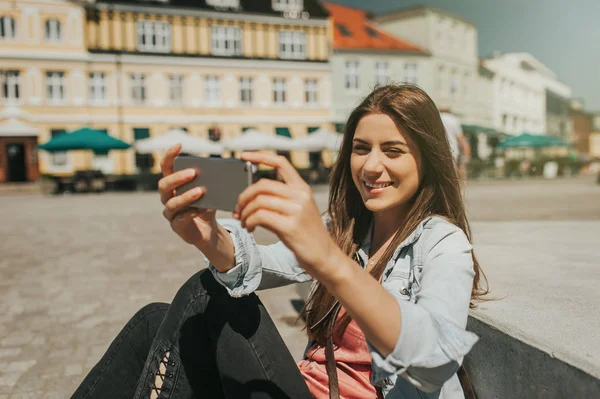 Młoda Piękna Kobieta Siedzi Centrum Miasta Biorąc Autoportret Jej Telefonu — Zdjęcie stockowe