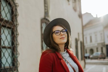 Gözlüklü genç hipster kadın şehir eski şehir, Avrupa'da bir şapka giyiyor