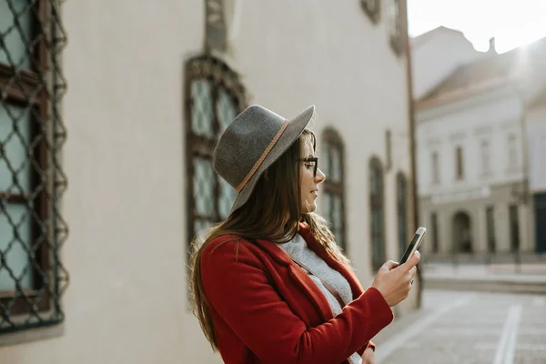 Fiatal Hipster Szemüveges Kezében Egy Okostelefon Visel Kalap Látszó Oldalán — Stock Fotó