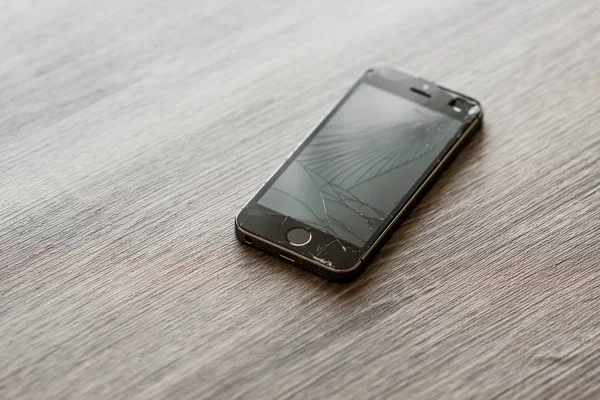 Gri arka planda kırık siyah telefon ekranı