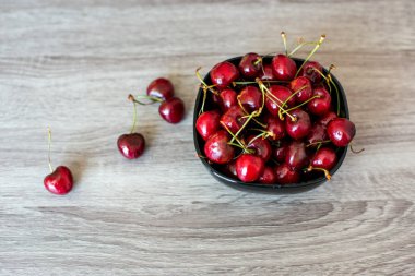 Ahşap gri arka planda tabakta taze kiraz. tatlı kiraz