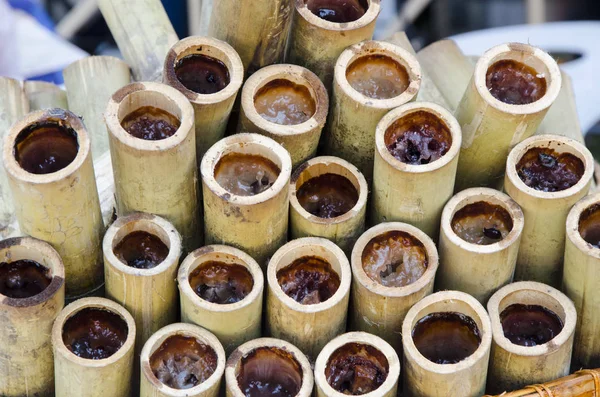 Bir sıra yapışkan pirinç bambuda pişiyor.