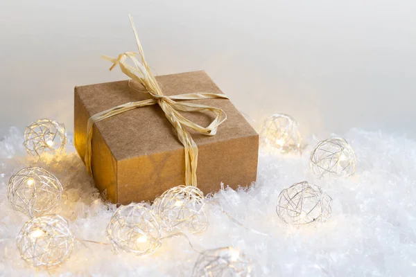 Κουτί Δώρων Και Χριστουγεννιάτικα Φώτα Στο Χιόνι Λευκό Φόντο Αντίγραφο — Φωτογραφία Αρχείου