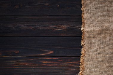 Koyu ahşap masada çuval bezi. Mutfak masasının üst manzarası. Taşralı. Boşluğu kopyala 