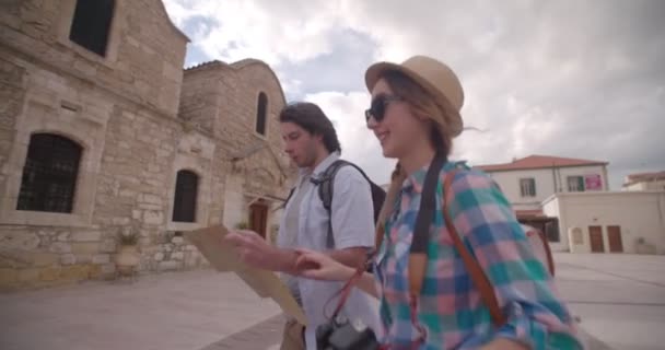 Молодая пара с картой прогулок по старой каменной деревне — стоковое видео