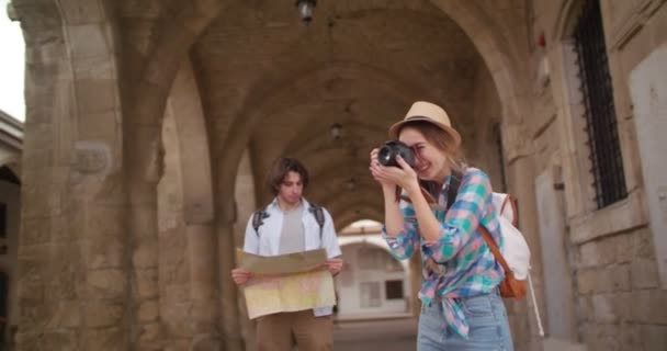 Giovani turisti con mappa e macchina fotografica che visitano la città vecchia medievale — Video Stock