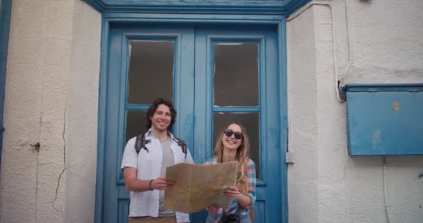Turistas com câmera e mapa na frente da porta velha — Vídeo de Stock