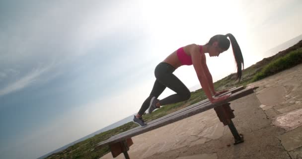 Adatta donna che fa addominali e cosce allenamento su una panchina — Video Stock