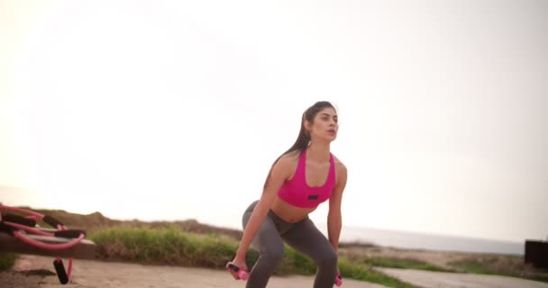 Mujer joven atleta entrenando al aire libre junto al mar — Vídeo de stock