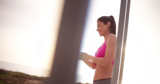 Mujer joven atleta en ropa deportiva preparándose para entrenar al aire libre — Vídeo de stock