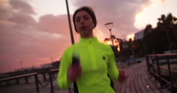 Přizpůsobit žena jogging a poslech hudby na její smartphone — Stock video