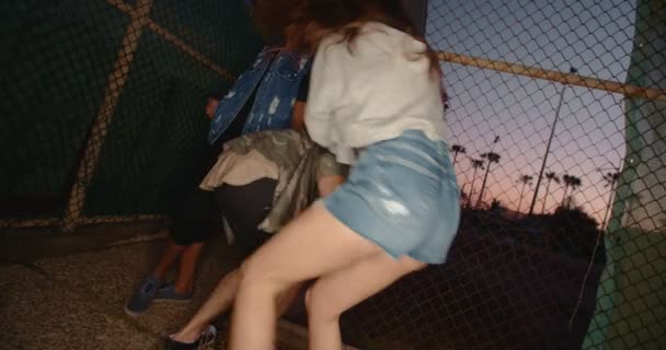 Teenage rebelové uniknout tím, že přestřihne drátěný plot — Stock video