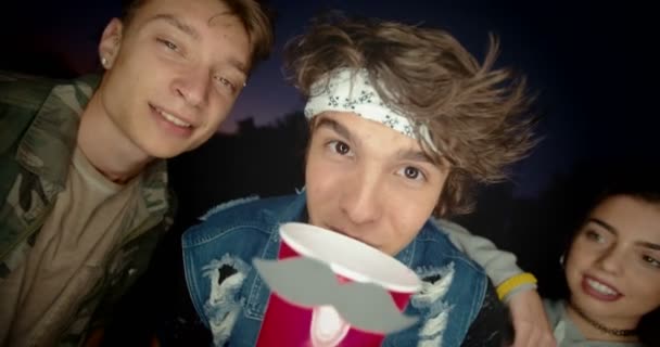 Teenage friends partying outdoors and drinking alcohol at night — Stock Video