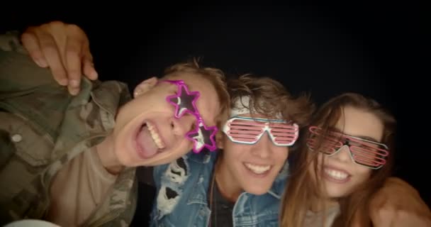 Група хіпстерських підлітків розважаються зі смішними окулярами — стокове відео