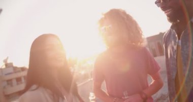 Çok ırklı arkadaşlar çatıdaki partide bira içip eğleniyorlar.