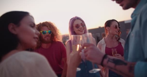 Друзі хіпстера п'ють шампанське і фліртують на даху літньої вечірки — стокове відео