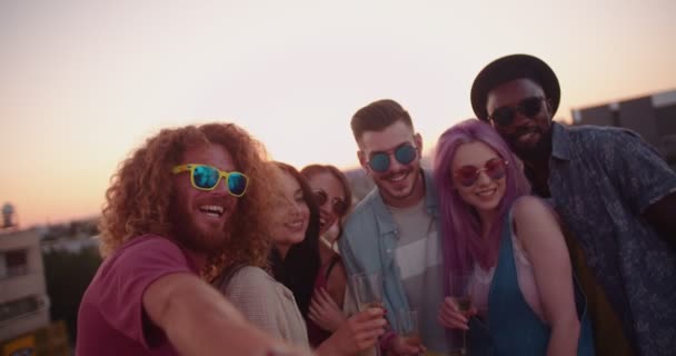 Друзі хіпстера з шампанським беруть селфі на літній вечірці на даху — стокове відео