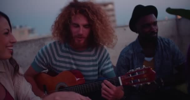 Amici multietnici che suonano la chitarra e cantano alla festa sul tetto — Video Stock