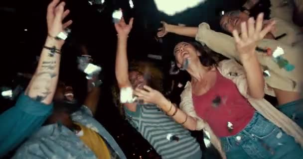 Jóvenes amigos multiétnicos bailando y festejando con confeti por la noche — Vídeos de Stock