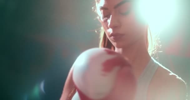 Ung atletisk kvinna tar av sig sina boxningshandskar efter träning — Stockvideo