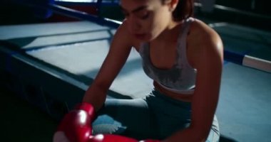 Yoğun bir antrenmandan sonra genç bayan boksör dinleniyor.