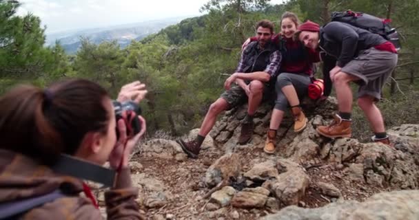 Genç yürüyüşçü arkadaşlar dağın tepesinde fotoğraf çekiyorlar. — Stok video