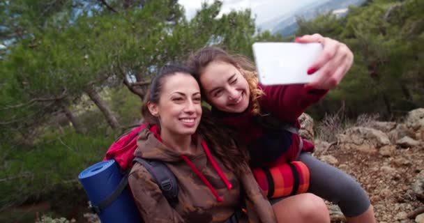 Genç bayan yürüyüşçü arkadaşlar dağda selfie çekiyorlar. — Stok video
