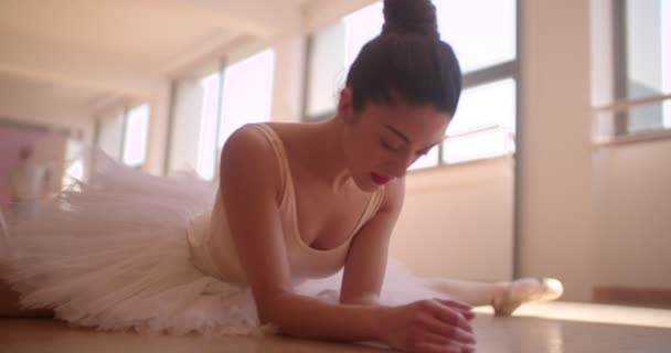 Young ballerina practising doing the splits in a dance studio — Stock Video