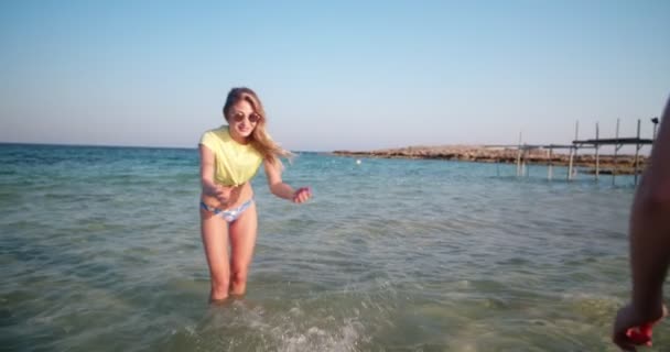 Vrouwen in badpak spelen met golven op het strand — Stockvideo