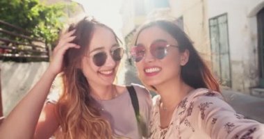 Genç bayan turistler eski İtalyan kasabasında selfie çekiyorlar.