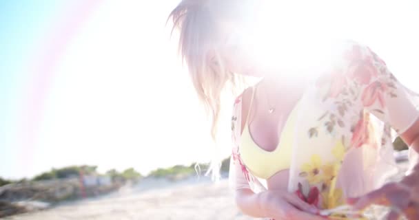 Mujer rubia joven con un kimono floral en la playa — Vídeo de stock