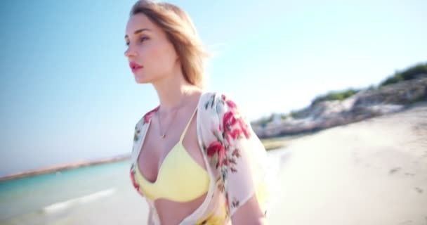 Όμορφη ξανθιά γυναίκα που διασκεδάζει περπατώντας στην παραλία — Αρχείο Βίντεο