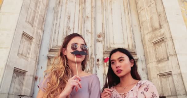 Femmes playinig avec de fausses moustaches et les lèvres dans la vieille rue — Video