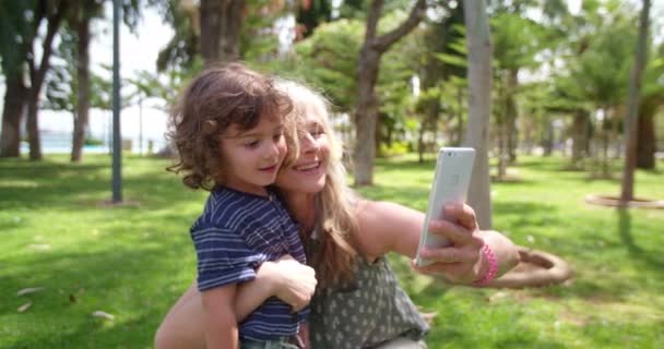 Mooie oma het nemen van selfies op haar smartphone met leuke kleinzoon — Stockvideo