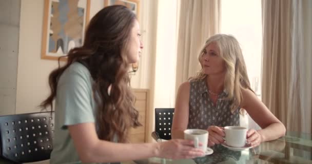 Μητέρα και ενήλικη κόρη κουβεντιάζουν πίνοντας καφέ στο σπίτι — Αρχείο Βίντεο