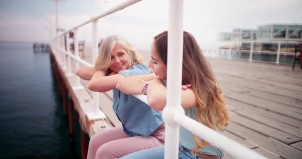 Gelukkig grootmoeder en kleindochter chatten zitten op pier — Stockvideo