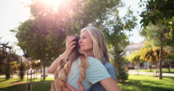 Mature mother and young daughter hugging in park — Stock Video