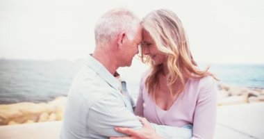 Denizde romantik yaşlı çift, birbirlerinin gözlerinin içine bakıyor.